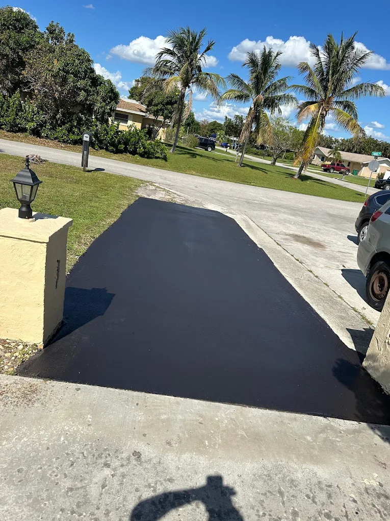 Freshly sealed black asphalt driveway apron