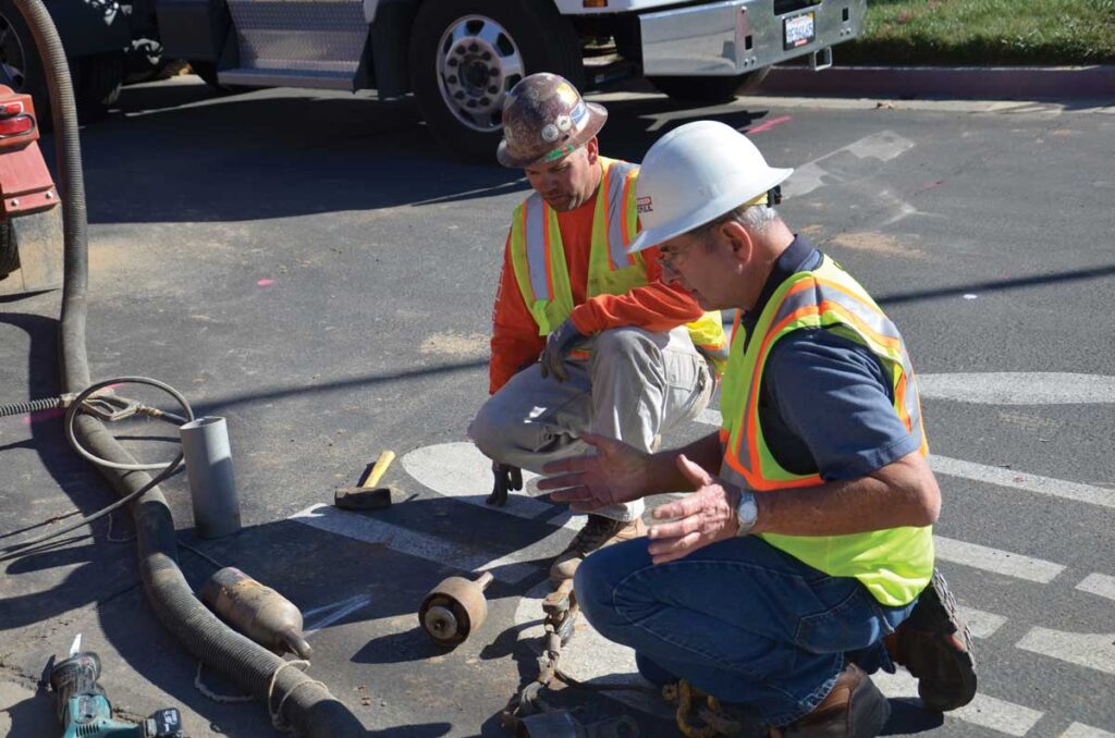 Crew inspecting asphalt during maintenance